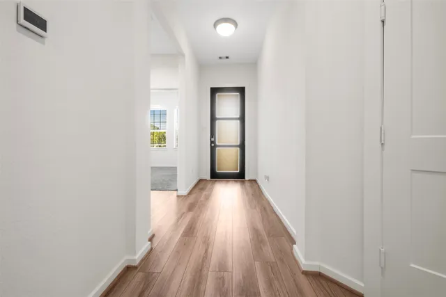 a view of a hallway with wooden floor