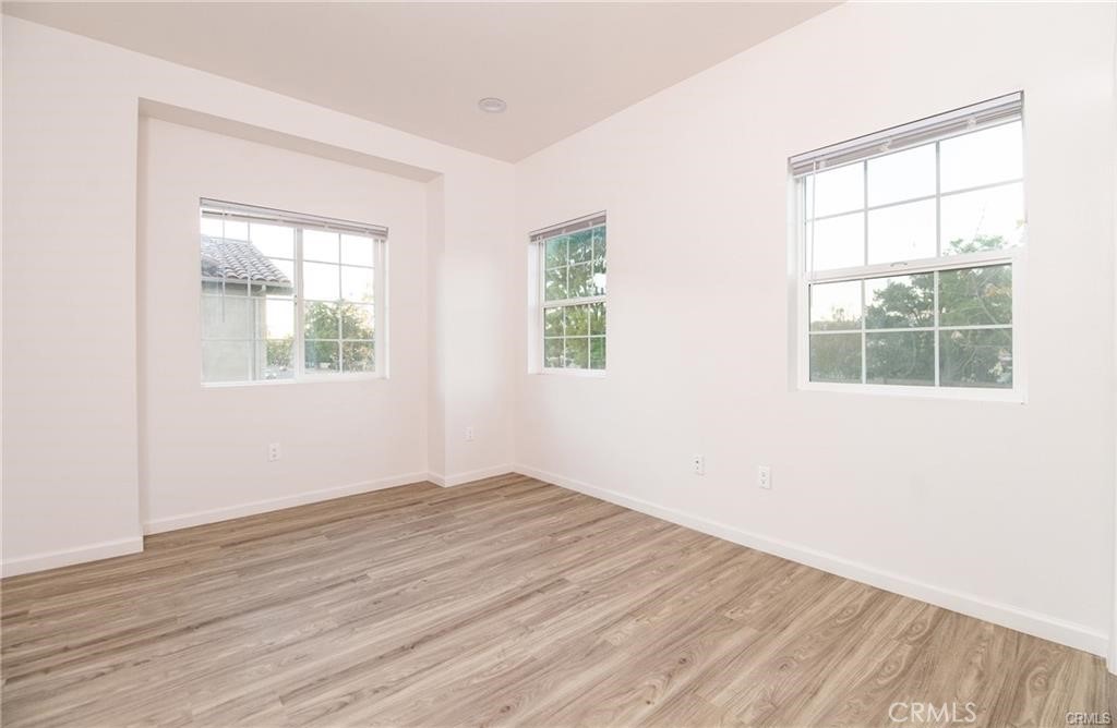 5502 East Los Angeles Avenue, Unit 3 Simi Valley, CA 93063 - Photo 20 of 48 an empty room with wooden floor and windows