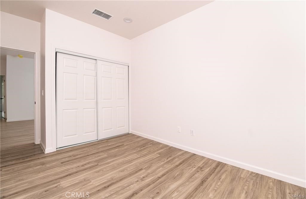 5502 East Los Angeles Avenue, Unit 3 Simi Valley, CA 93063 - Photo 21 of 48 an empty room with wooden floor and white walls