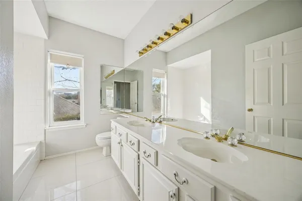 a spacious bathroom with a double vanity sink and a mirror