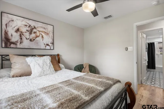 a bedroom with a bed and a painting on the wall