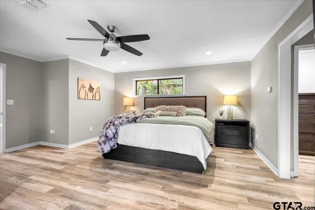 a bedroom with a large bed and a ceiling fan