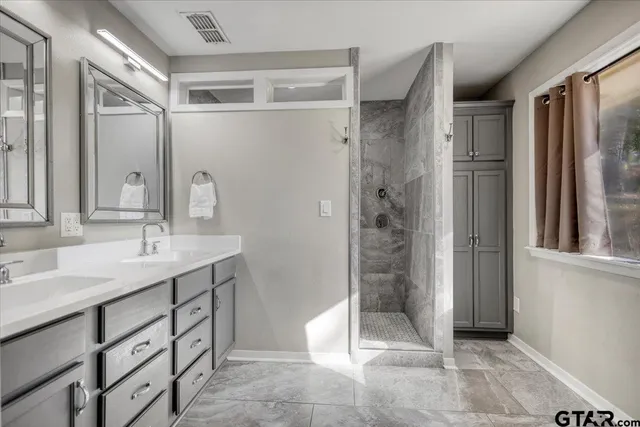 a bathroom with a shower sink and mirror