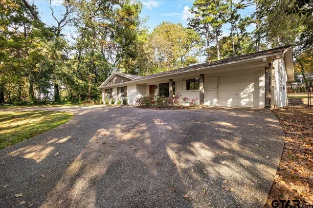 a front view of a house with yard and trees