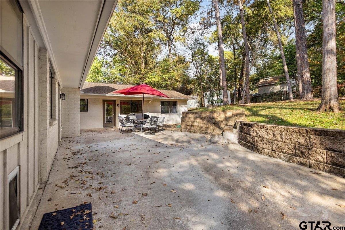 441 Hideaway Lane Hideaway, TX 75771 - Photo 34 of 38 a view of a patio with a table and chairs under an umbrella