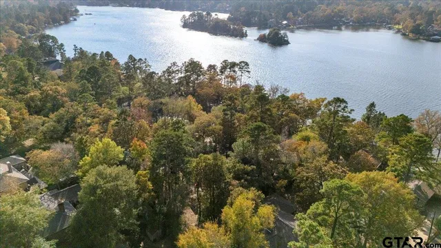 an aerial view of a house with a yard and lake view