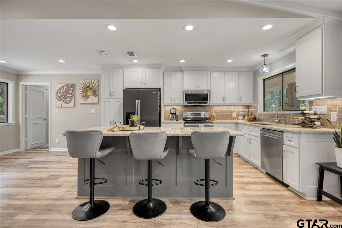 441 Hideaway Lane Hideaway, TX 75771 - Photo 5 of 38 a kitchen with stainless steel appliances granite countertop a refrigerator a stove a sink dishwasher and a dining table with wooden floor