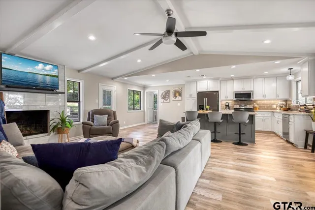 a living room with furniture kitchen view and a fireplace