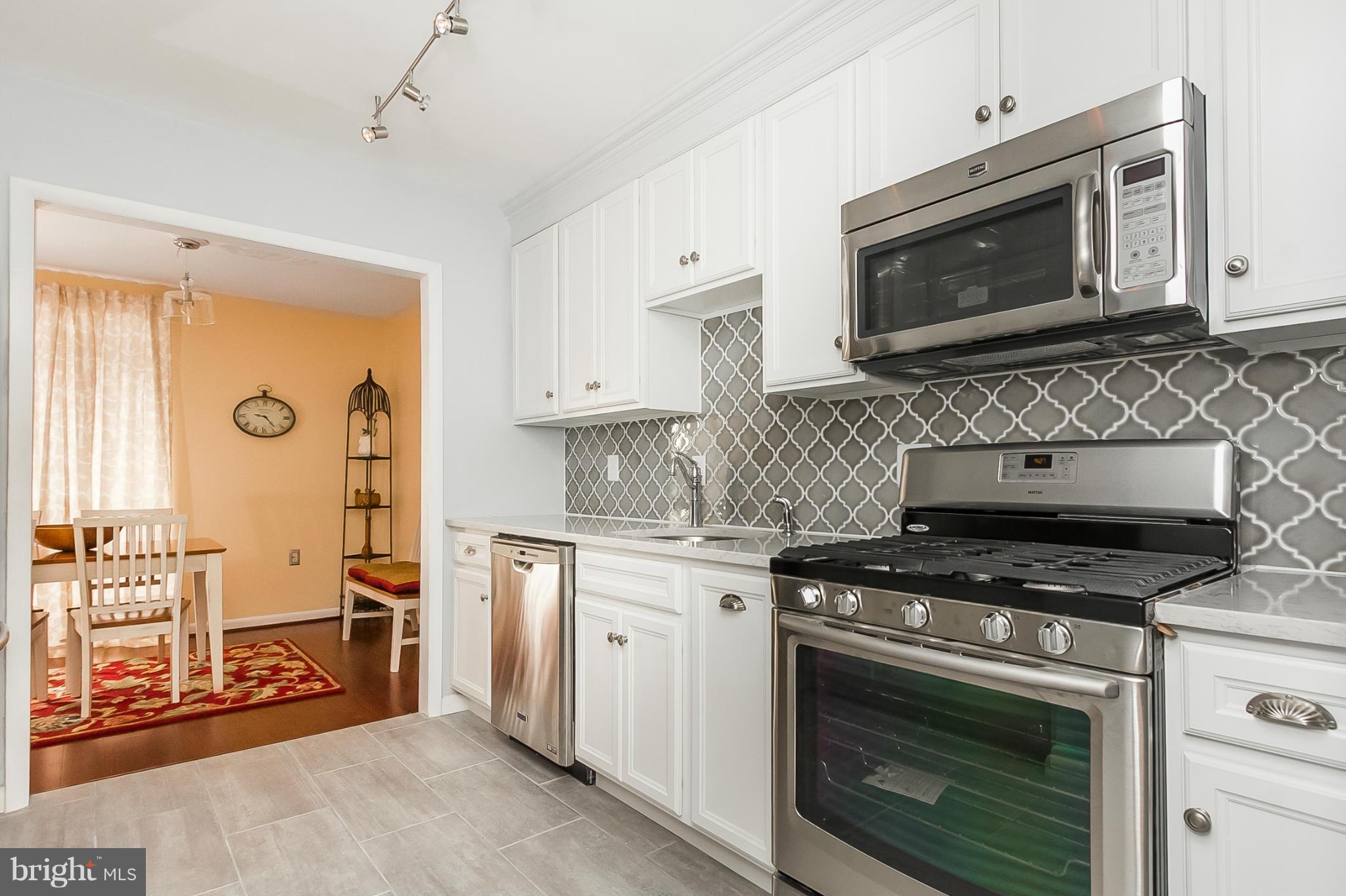 119 Cross Keys Road, Unit R119E Baltimore, MD 21210 - Photo 2 of 22 a kitchen with stainless steel appliances granite countertop a stove microwave and cabinets