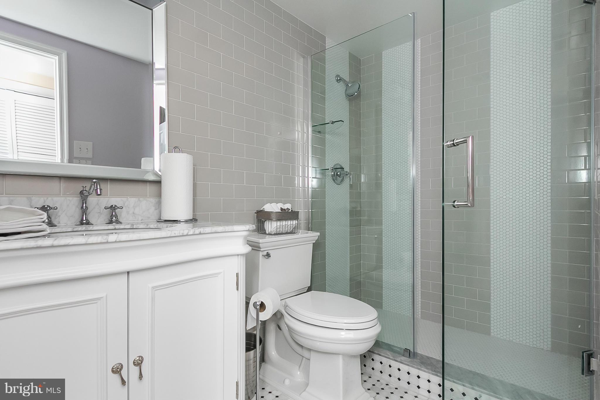 119 Cross Keys Road, Unit R119E Baltimore, MD 21210 - Photo 14 of 22 a bathroom with a toilet sink vanity and shower