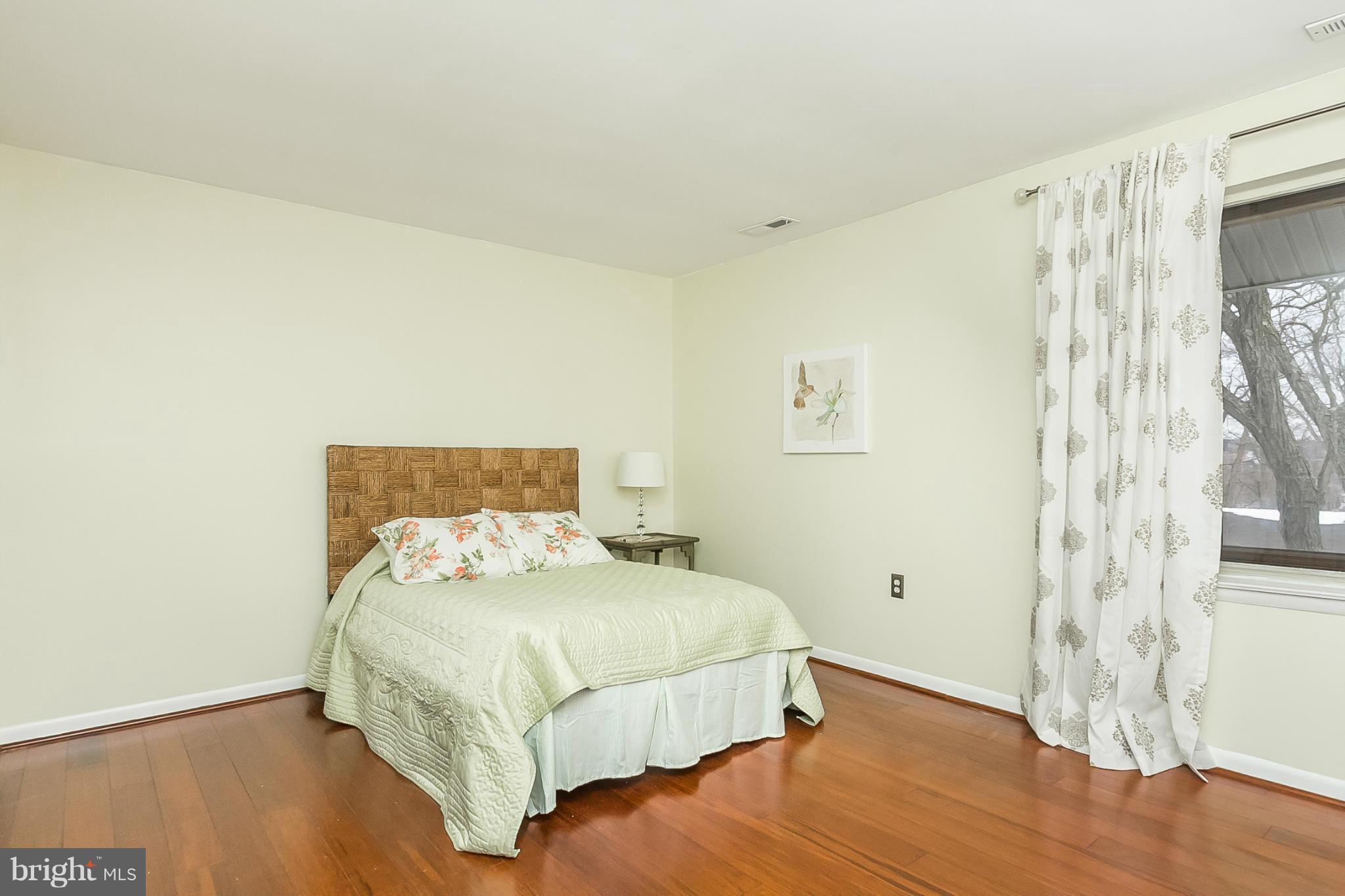 119 Cross Keys Road, Unit R119E Baltimore, MD 21210 - Photo 17 of 22 a bedroom with a bed and wooden floor