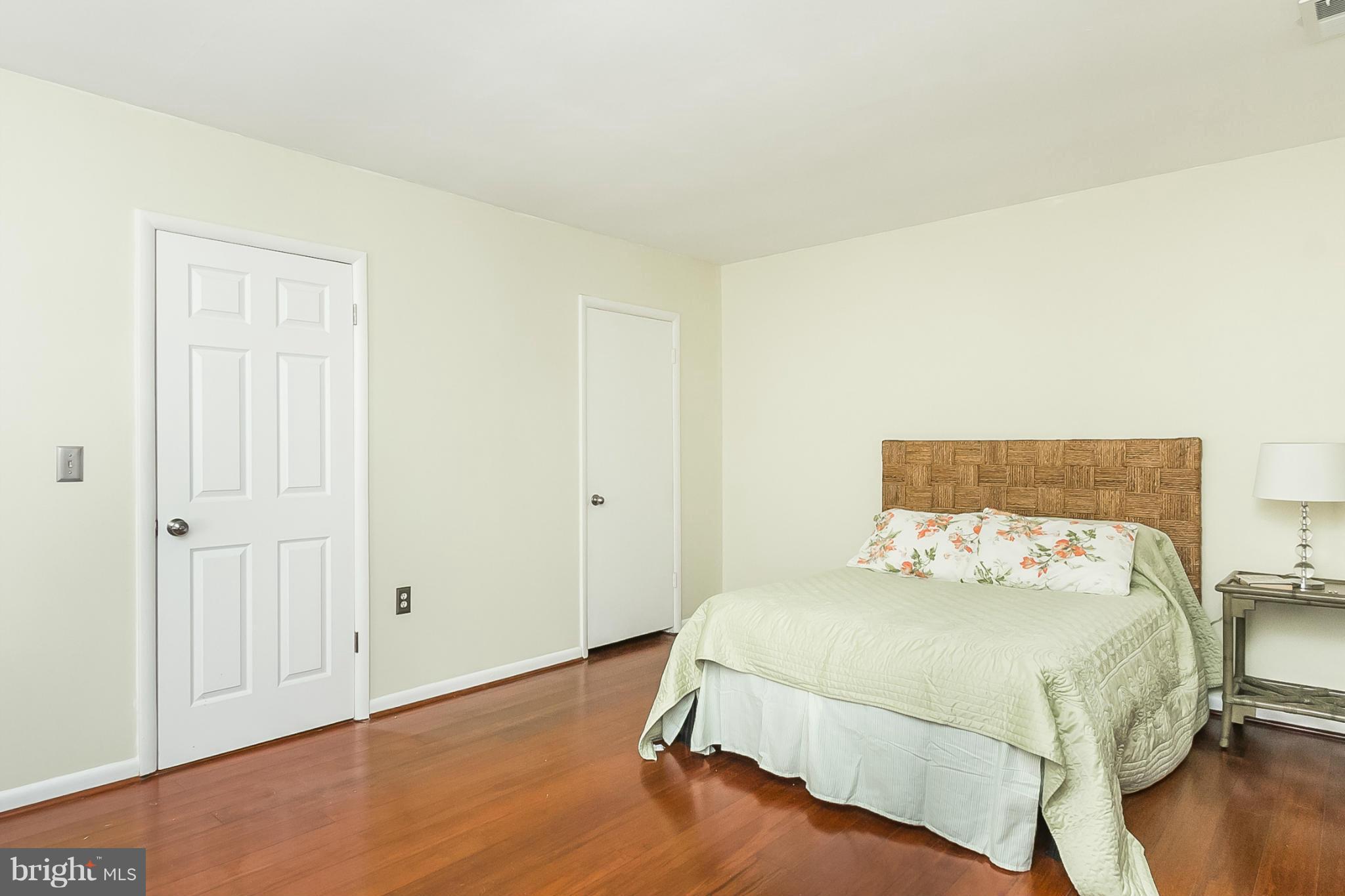 119 Cross Keys Road, Unit R119E Baltimore, MD 21210 - Photo 18 of 22 a bedroom with a bed and wooden floor