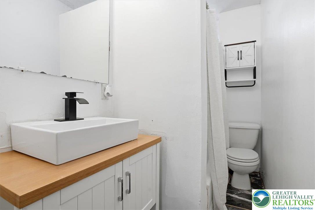 1171 Mechanic Street Bethlehem, PA 18015 - Photo 14 of 25 a bathroom with a sink a toilet and mirror