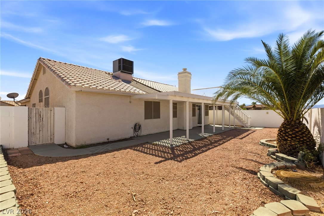 904 Shadowfax Road Henderson, NV 89015 - Photo 24 of 31 A spacious backyard features a covered concrete patio and low-maintenance desert landscaping.