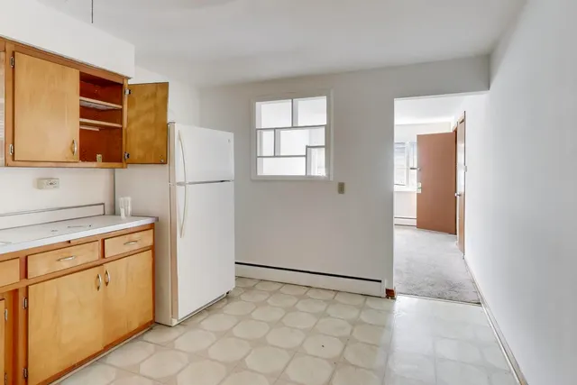 a view of a kitchen with white cabinets and wooden floor