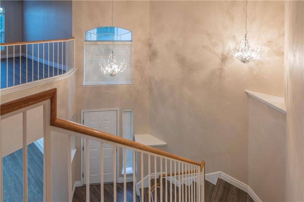 12017 Springs Head Loop Austin, TX 78717 - Photo 10 of 25 A graceful staircase with wood flooring guides the eye toward a grand entry with sophisticated chandeliers.