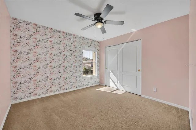 an empty room with fan and windows