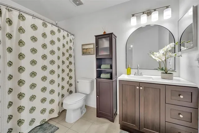 a spacious bathroom with a double vanity sink toilet and a mirror