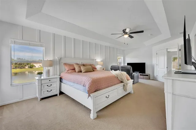 a spacious bedroom with a bed and a chandelier