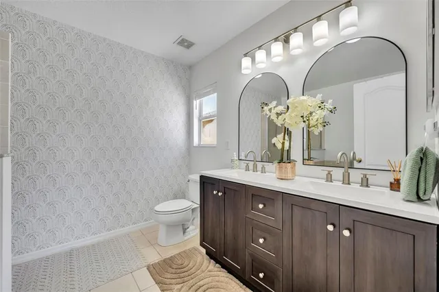 a bathroom with a double vanity sink mirror and toilet