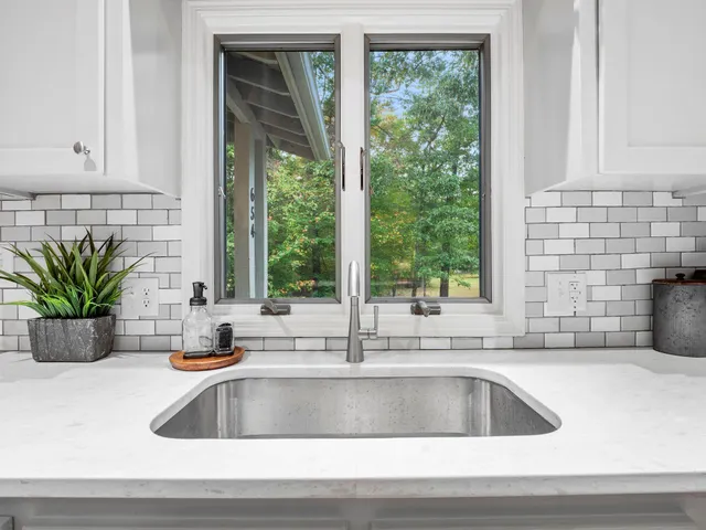 a kitchen with a stove a sink a dining table and chairs