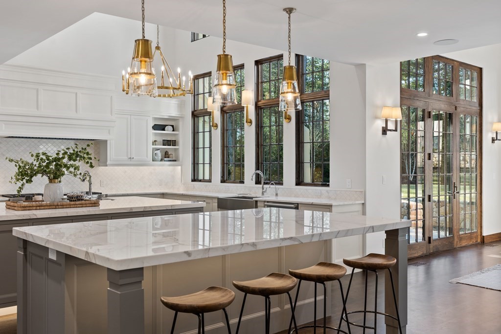 17 Bridle Pth Path Weston, MA 02493 - Photo 14 of 42 a kitchen with granite countertop a table chairs and a chandelier