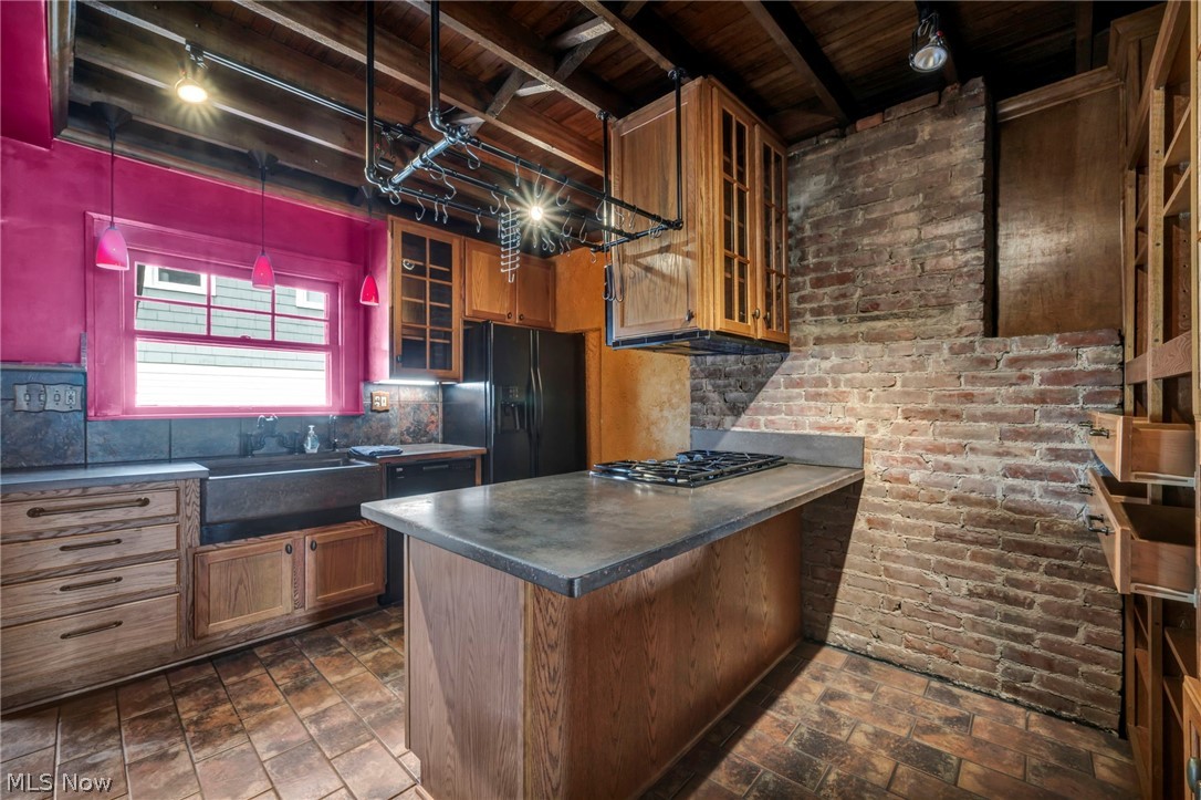 3272 Tullamore Road Cleveland, OH 44118 - Photo 22 of 47 Kitchen with brick wall, glass fronted cabinets, track lighting, dark countertops, and a peninsula