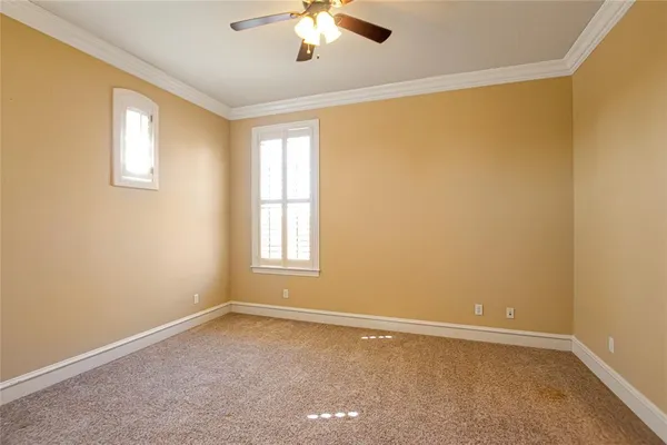 an empty room with closet and a ceiling fan