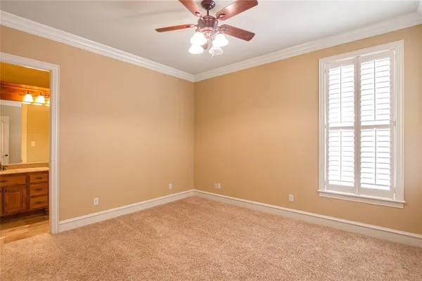 an empty room with a chandelier fan and closet area