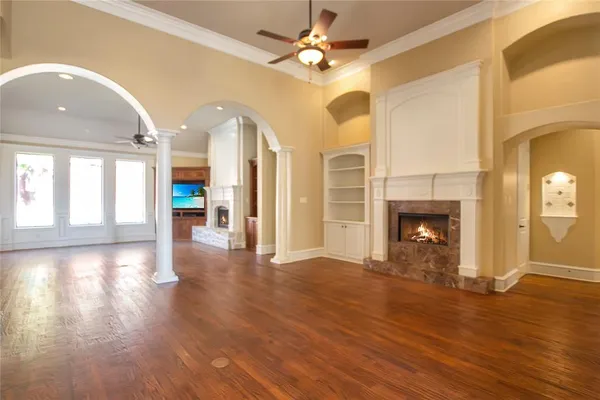 a view of a big room with wooden floor fireplace and windows