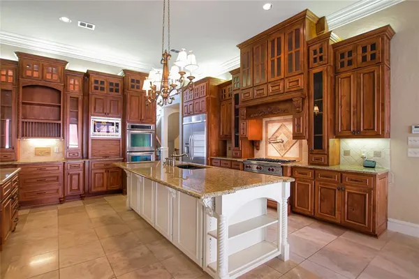 a kitchen with stainless steel appliances granite countertop a sink refrigerator and cabinets