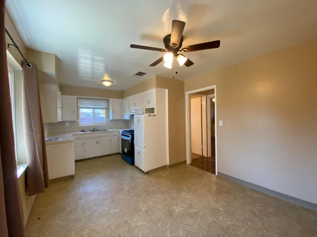 a room with refrigerator and ceiling fan