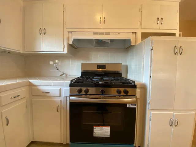 a stove top oven sitting inside of a kitchen