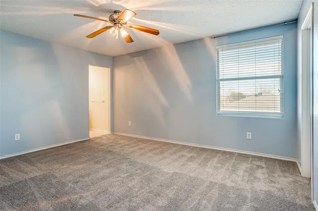 a view of a room with a window and a chandelier fan