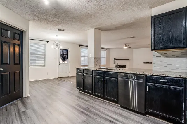 a kitchen with stainless steel appliances granite countertop a stove a sink and a refrigerator