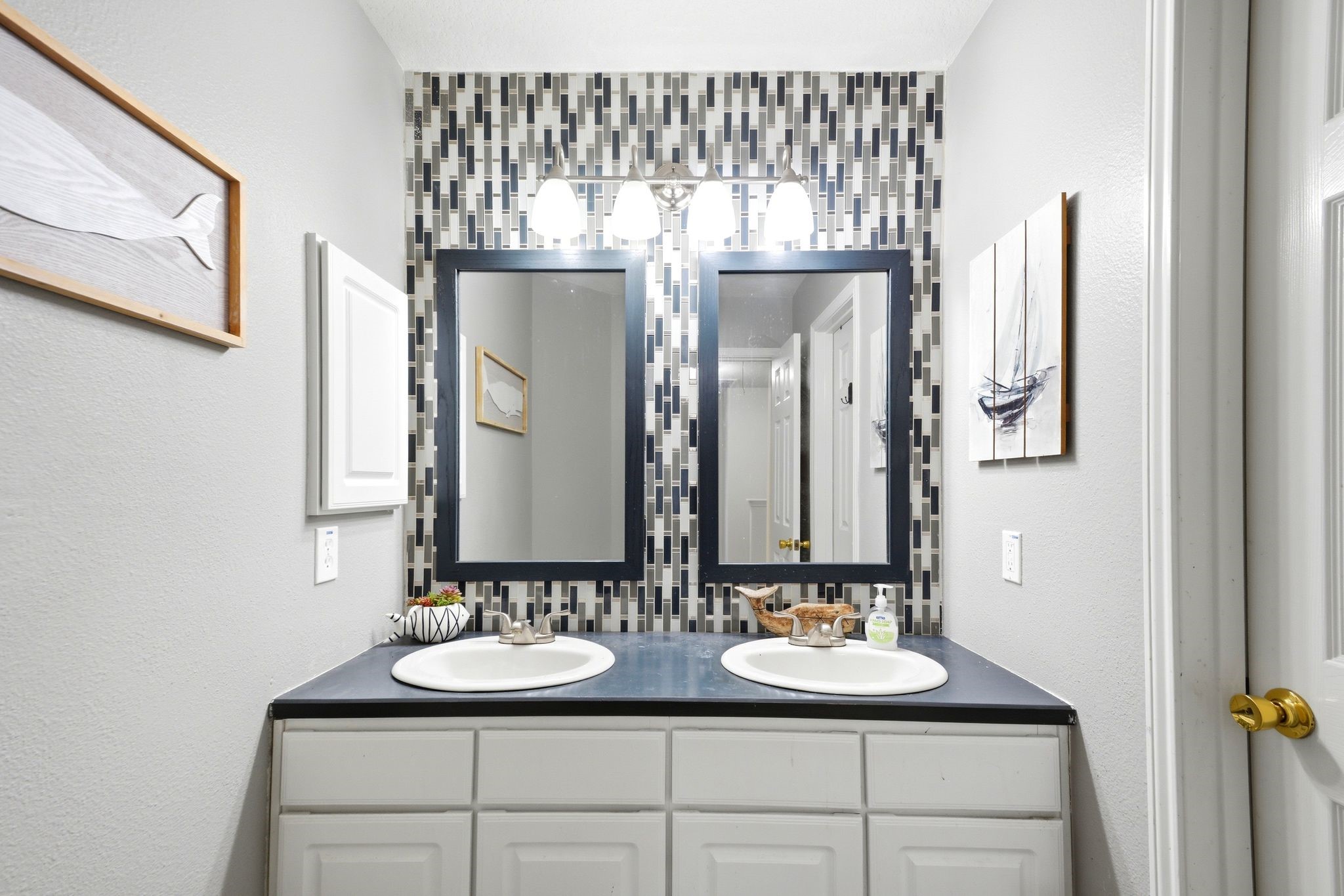 16954 Tableland Trail Conroe, TX 77385 - Photo 28 of 33 Updated bathroom featuring dual sinks, stylish accent wall detailing, and ample counter space for added convenience.