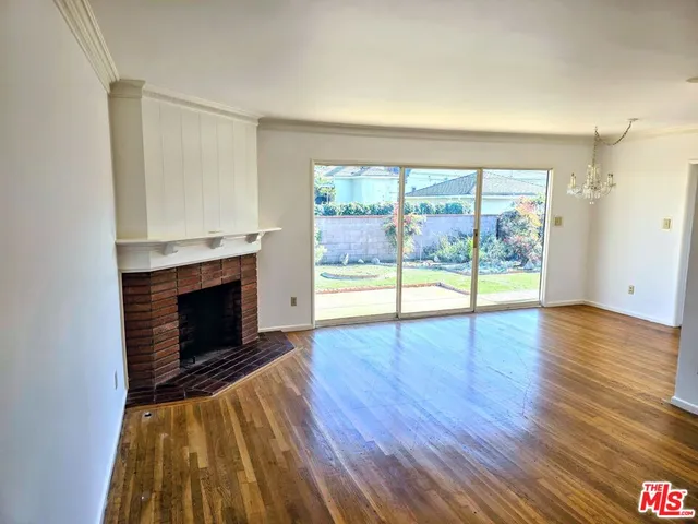 a view of empty room with wooden floor and fireplace