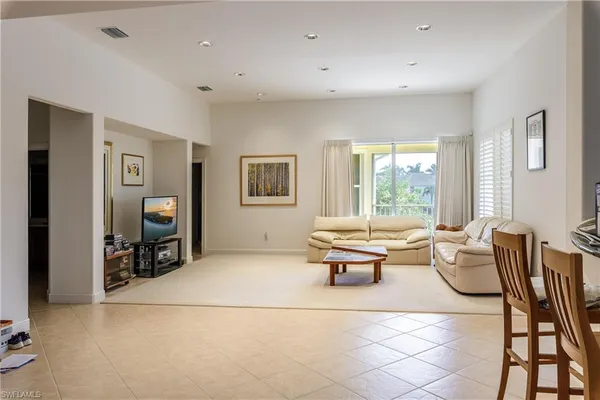 a living room with furniture a flat screen tv and a large window