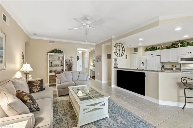 a living room with furniture a rug and kitchen view