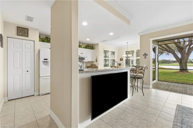 a kitchen view with stainless steel appliances kitchen island granite countertop a refrigerator and a sink