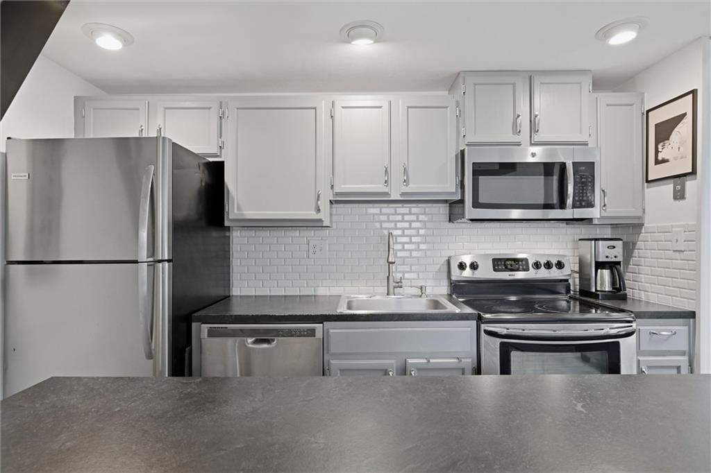 580 Maple Court Hidden Valley, PA 15502 - Photo 5 of 28 a kitchen with stainless steel appliances a refrigerator a stove a microwave and cabinets