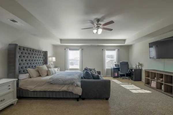 a bedroom with a large bed a couch and dresser