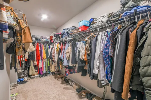a view of walk in closet with clothes