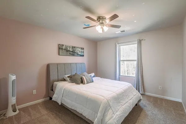 a bedroom with a large bed and a window