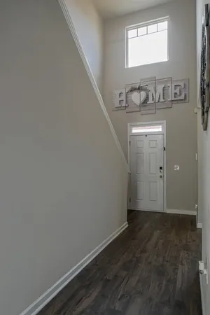 a view of a hallway with wooden floor and a sink