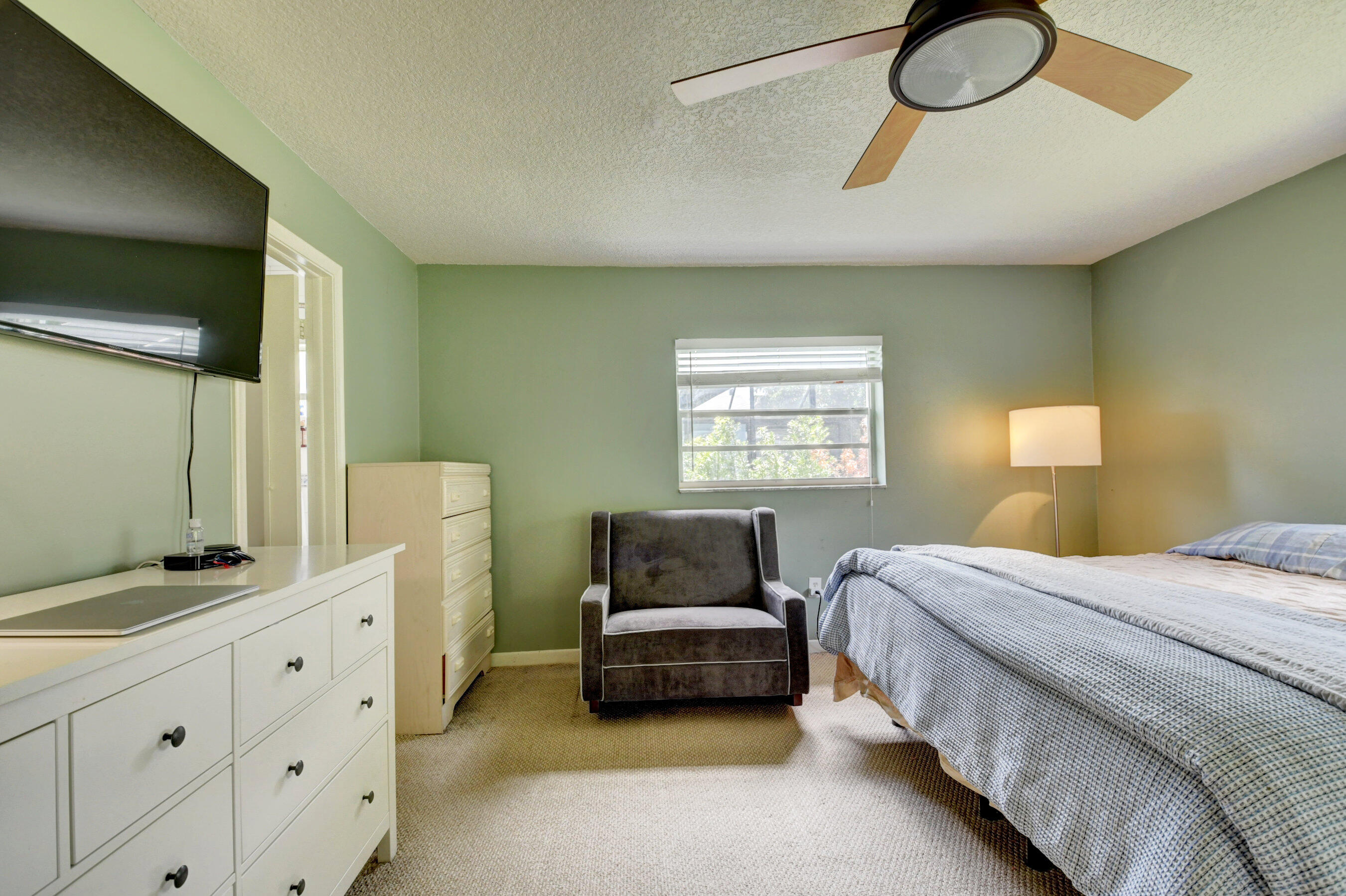 22093 Southwest 58th Avenue Boca Raton, FL 33428 - Photo 16 of 36 a bedroom with a bed and a chandelier