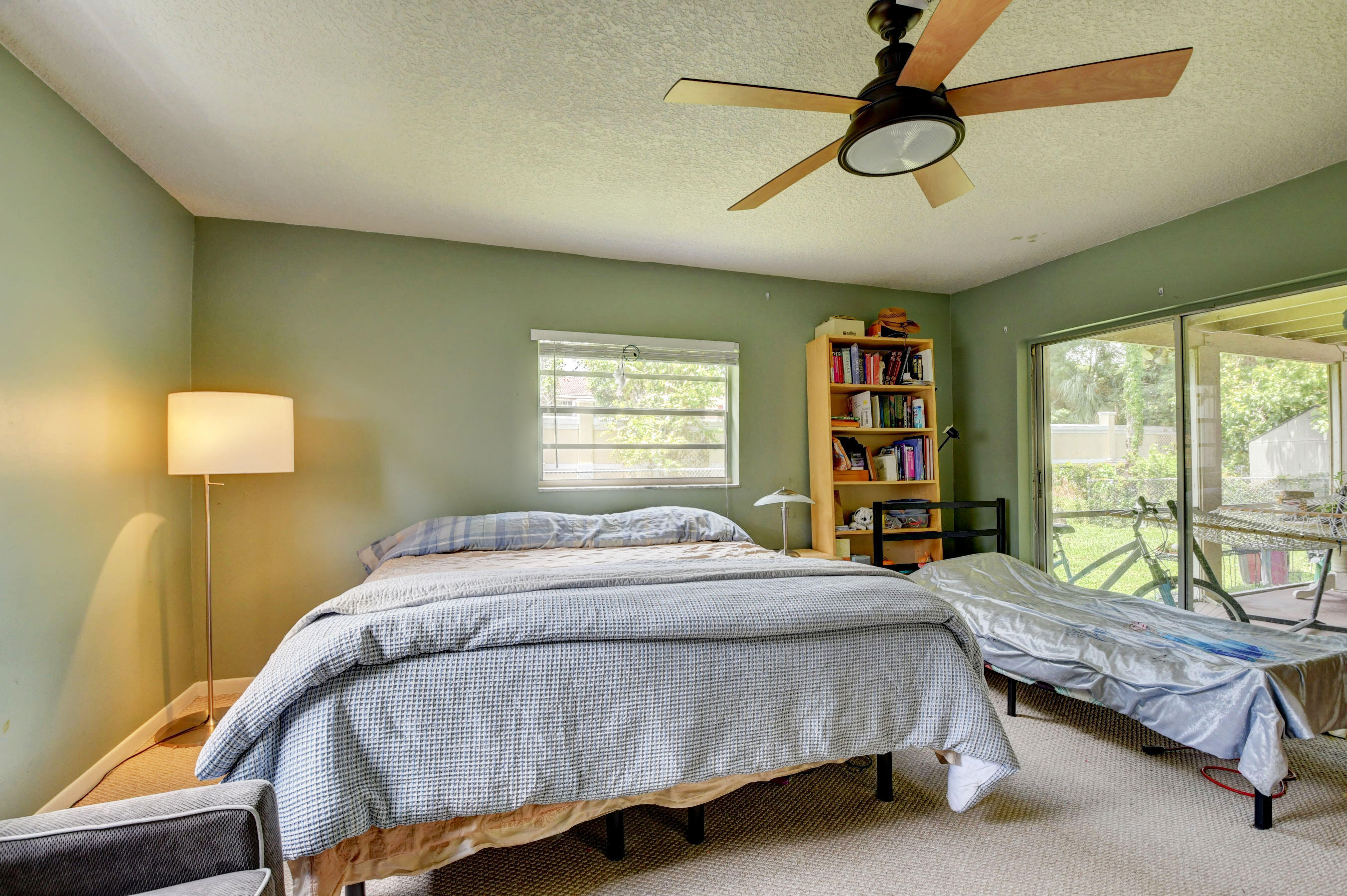 22093 Southwest 58th Avenue Boca Raton, FL 33428 - Photo 17 of 36 a bedroom with a bed a bookshelf and a large window