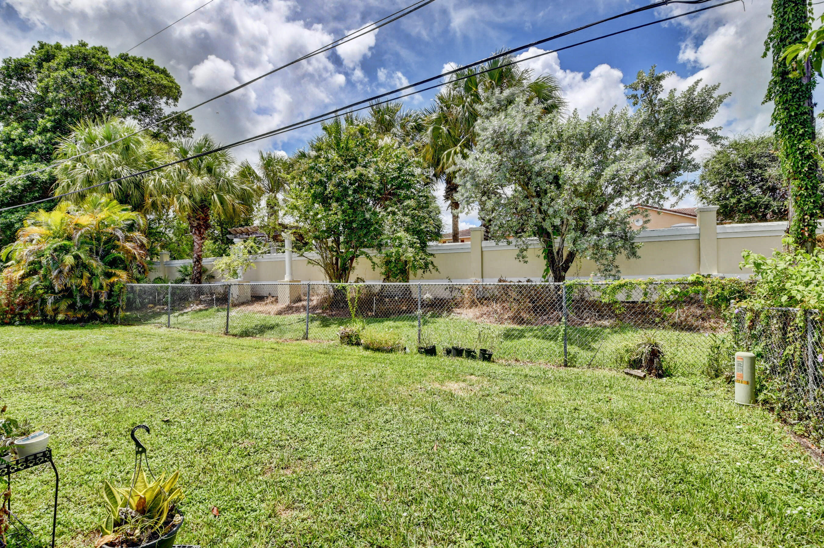 22093 Southwest 58th Avenue Boca Raton, FL 33428 - Photo 28 of 36 a backyard of a house with lots of green space and fountain