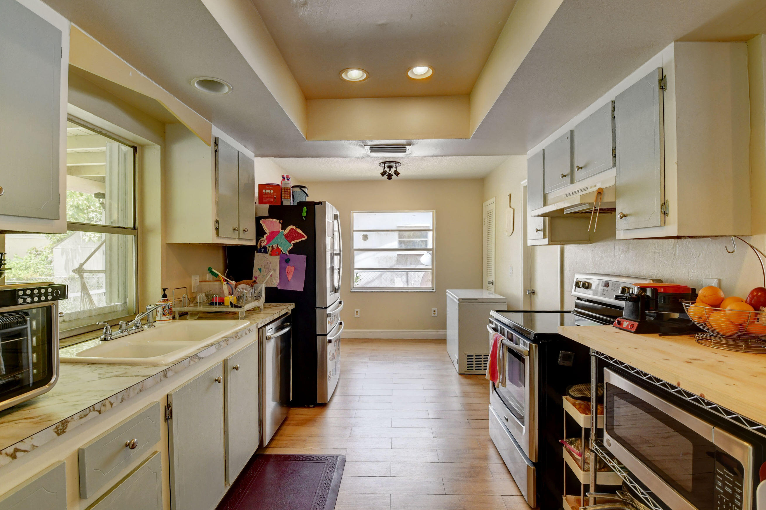 22093 Southwest 58th Avenue Boca Raton, FL 33428 - Photo 4 of 36 a kitchen that has a lot of cabinets in it and wooden floors