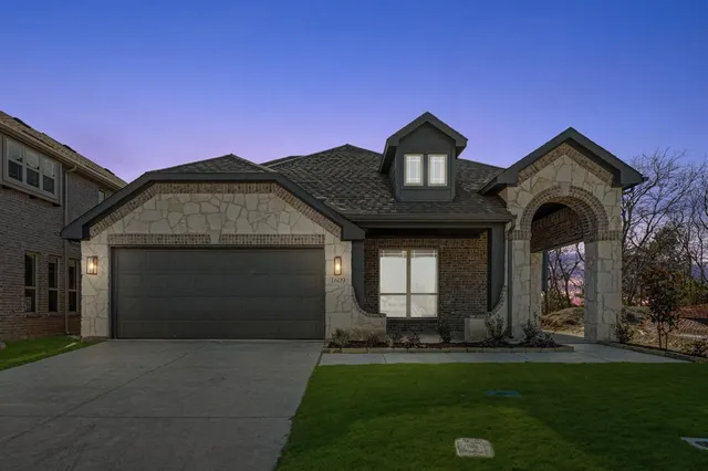 a front view of a house with a garden and garage
